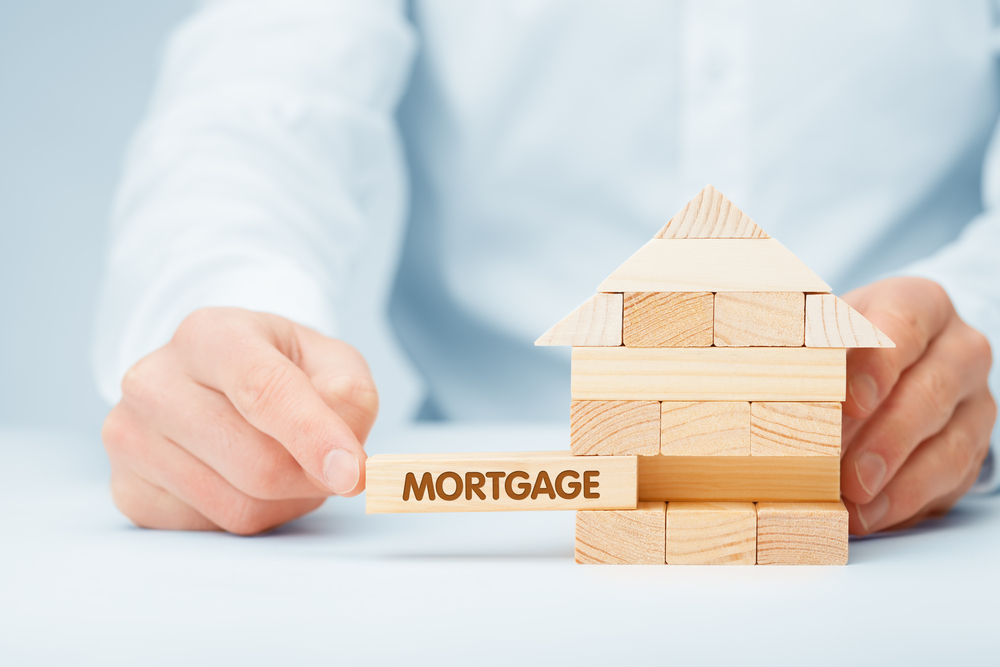 a small house made of toy building blocks with the word "mortgage" printed on it